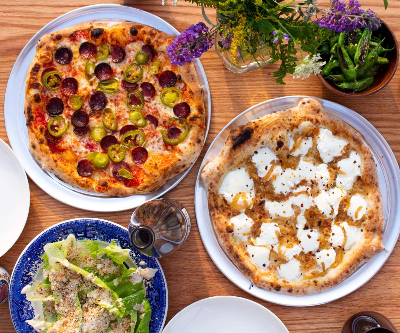 A full table at Buxton's: two pies and a chopped salad on the wood